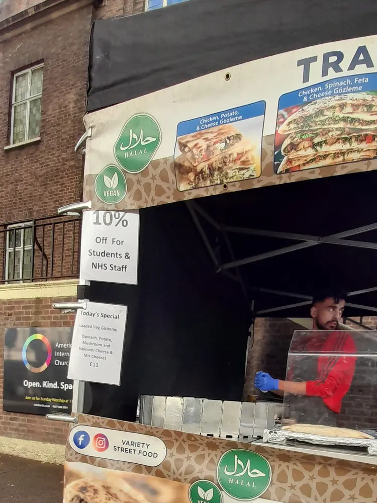 Street food stall with halal and vegan badges, a Today's Special card and a 10% off students and NHS staff sign
